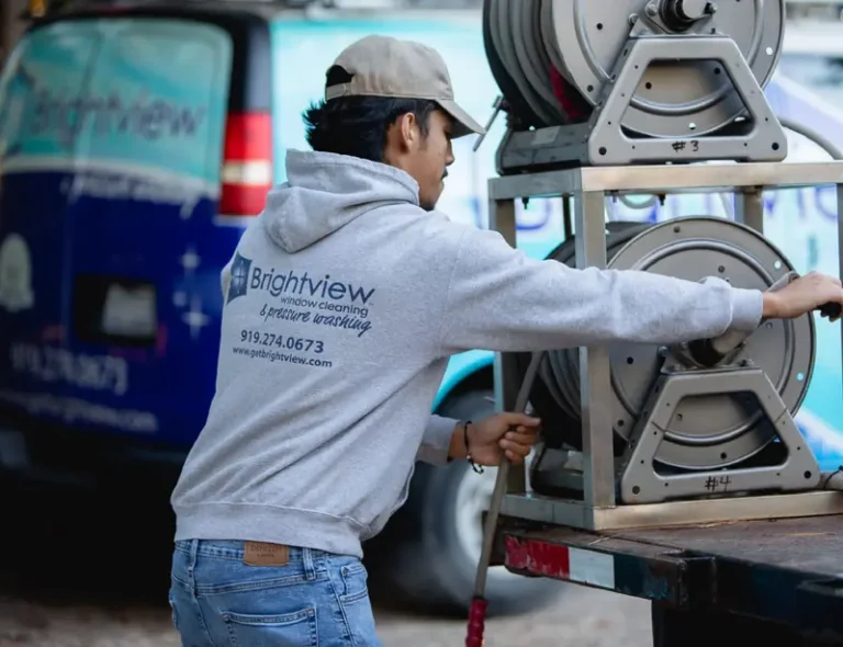 Technician working the hose reels on a Brightview equipment trailer