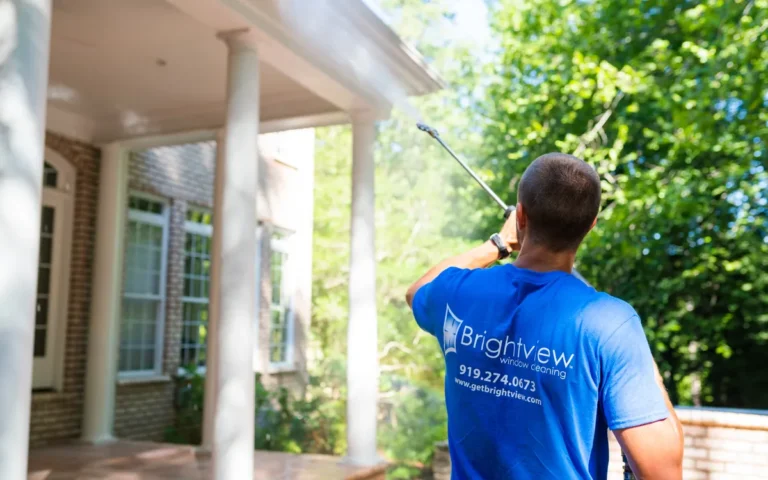 Brightview technician washing a home’s front porch and columns
