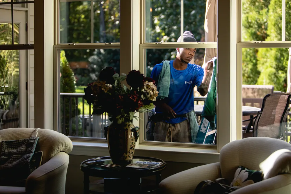 View from a living room as a Brightview technician cleans the outside of the windows